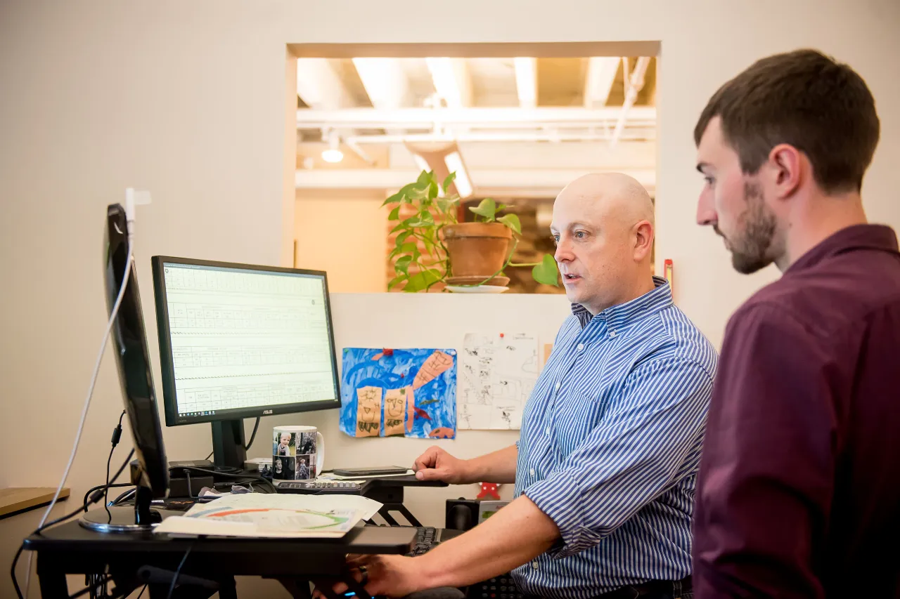 Engineers look at data on computer monitors